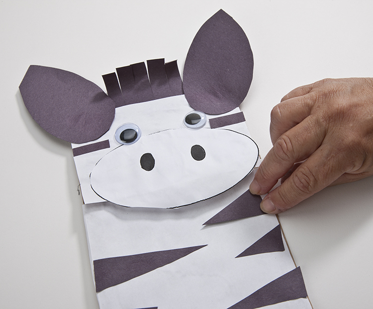 Gluing stripes on the zebra puppet