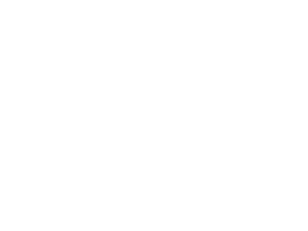 Sloth bear next to a bed.
