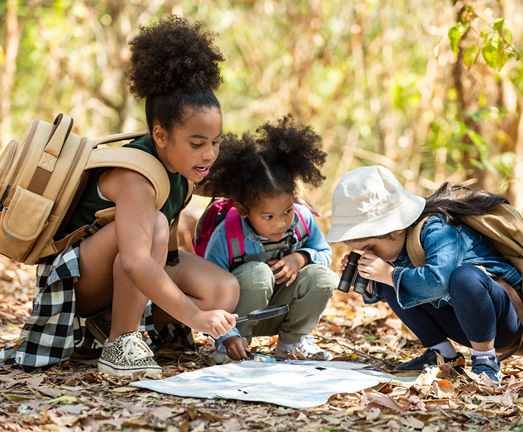 children reading map and exploring woods